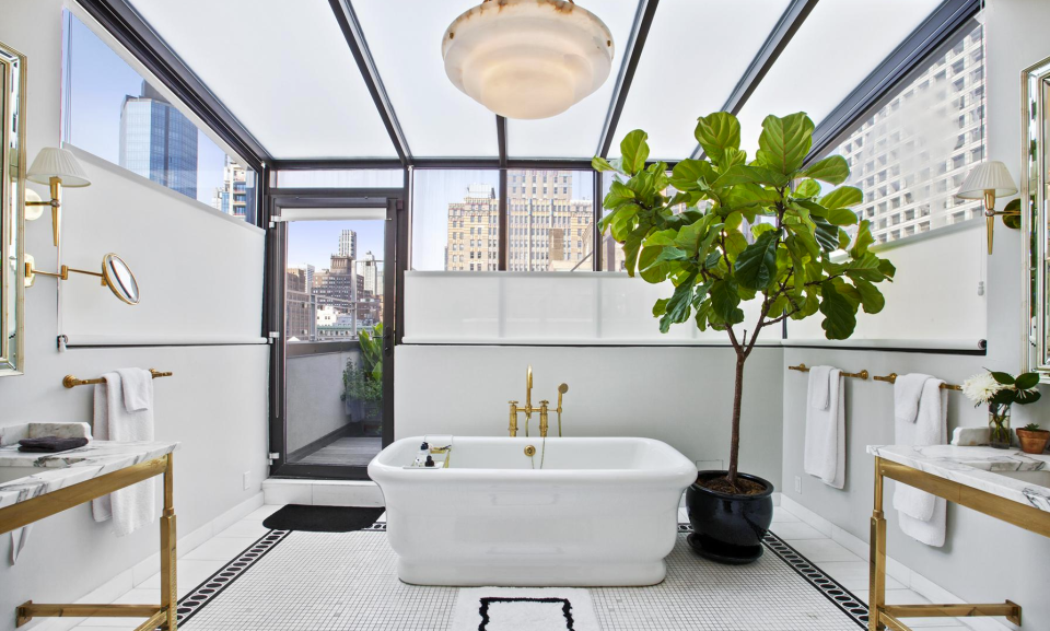 <p>Besides luxuries such as an oversized soaker tub, dual marble sinks and a rain shower, the bathroom’s glass ceiling offers breathtaking views. (Douglas Elliman) </p>