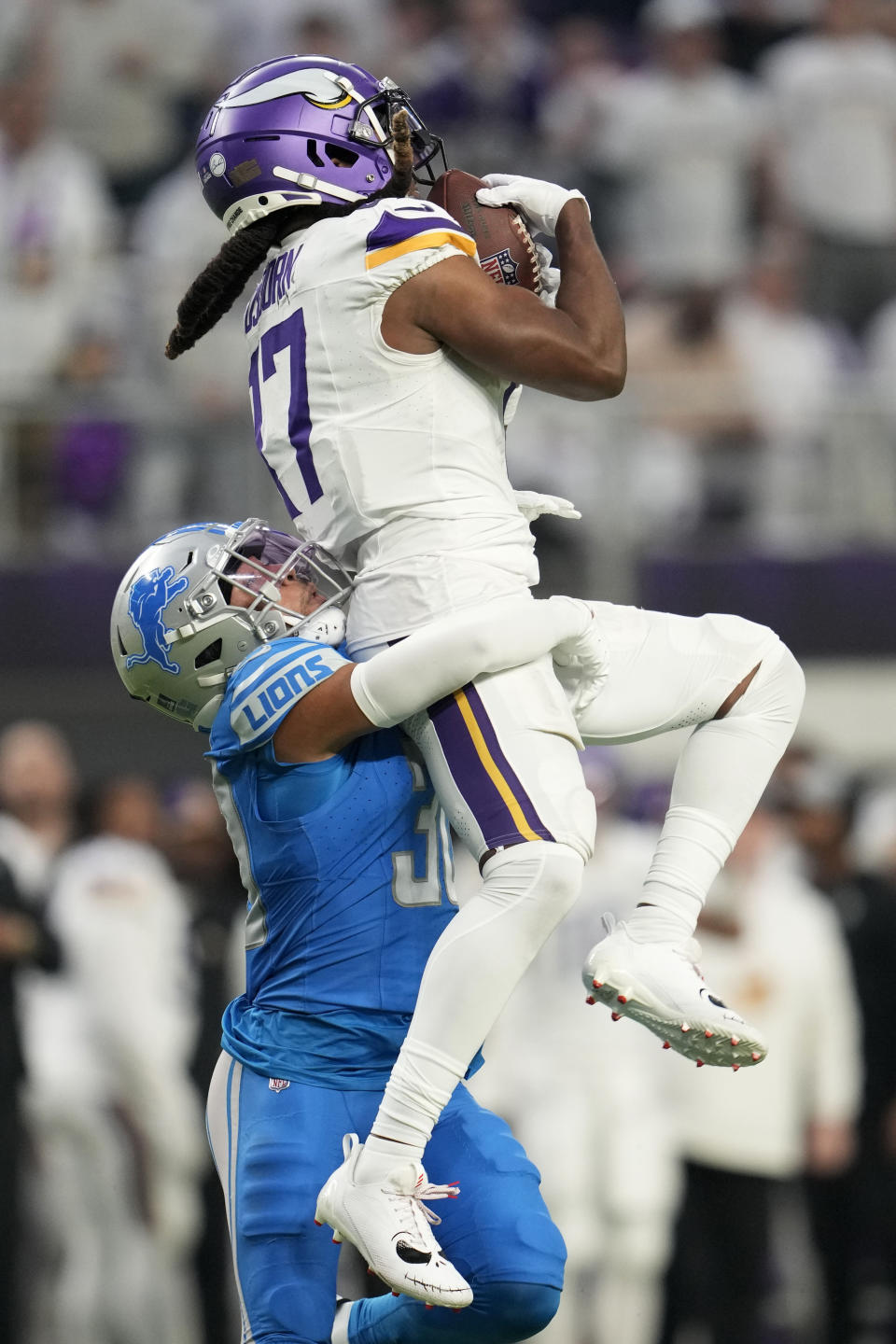 Minnesota Vikings wide receiver K.J. Osborn (17) catches a pass over Detroit Lions cornerback Khalil Dorsey (30) during the second half of an NFL football game, Sunday, Dec. 24, 2023, in Minneapolis. (AP Photo/Abbie Parr)