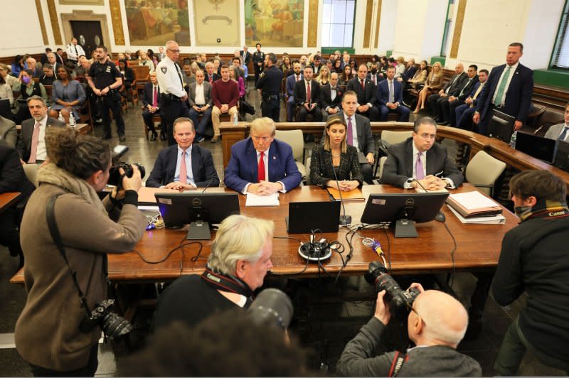 Former President Donald Trump is surrounded by cameras and his attorneys as he sits in New York State Supreme Court during his civil fraud trial Thursday. Pool Photo by Michael M. Santiago/UPI