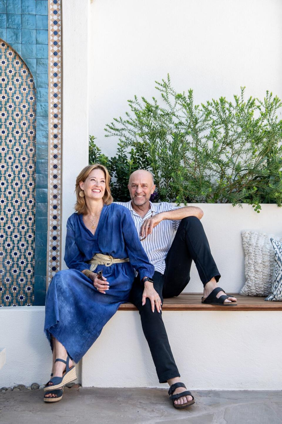 Nicole Fitzgerald and Rick Steil sit on a bench next to a fountain