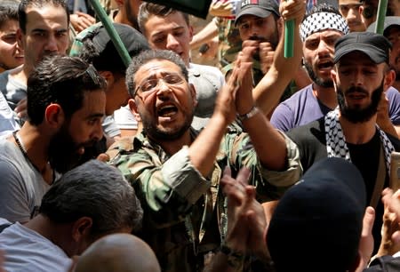 A Palestinian refugee gestures as he takes part in a rally at Yarmouk Palestinian camp in Damascus