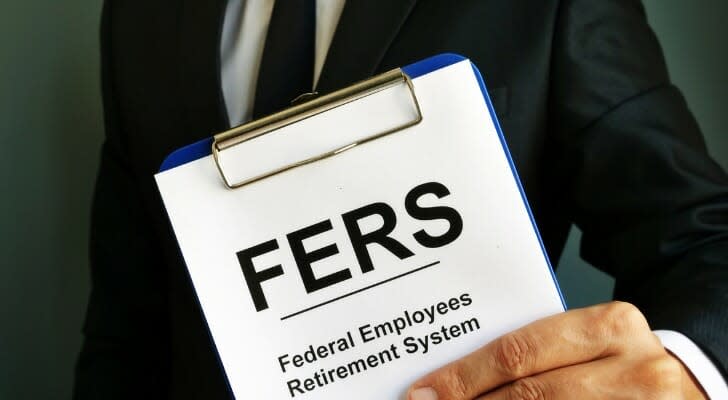 Man in a suit holding a clipboard with a paper on it that says, "Federal Employees Retirement System"