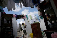 <p>A girl walks out of her house destroyed by Hurricane Matthew in the outskirts of Port Salut, Haiti, October 7, 2016. (REUTERS/Andres Martinez Casares)</p>