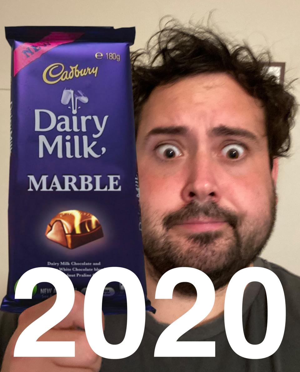 A man holding a block of Cadbury Dairy Milk Marble chocolate