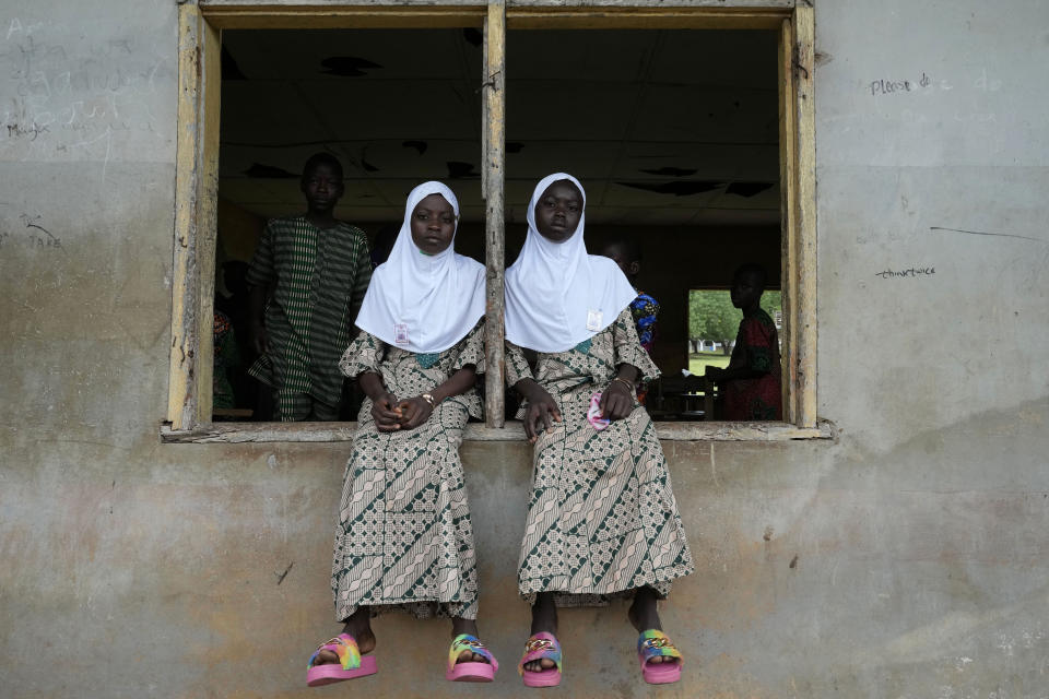 Twins Taiwo Asisi, left, and Kehinde Asisi, 13, students of Igbo-Ora grammar secondary school attends the annual twins festival in Igbo-Ora South west Nigeria, Saturday , Oct. 8, 2022. The town holds the annual festival to celebrate the high number of twins and multiple births. (AP Photo/Sunday Alamba)