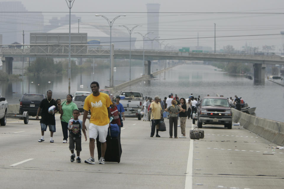 Residents of New Orleans rescued by police boats walk from floodwaters in front of the Superdome on Sept. 1, 2005. (Photo: Jason Reed / Reuters)
