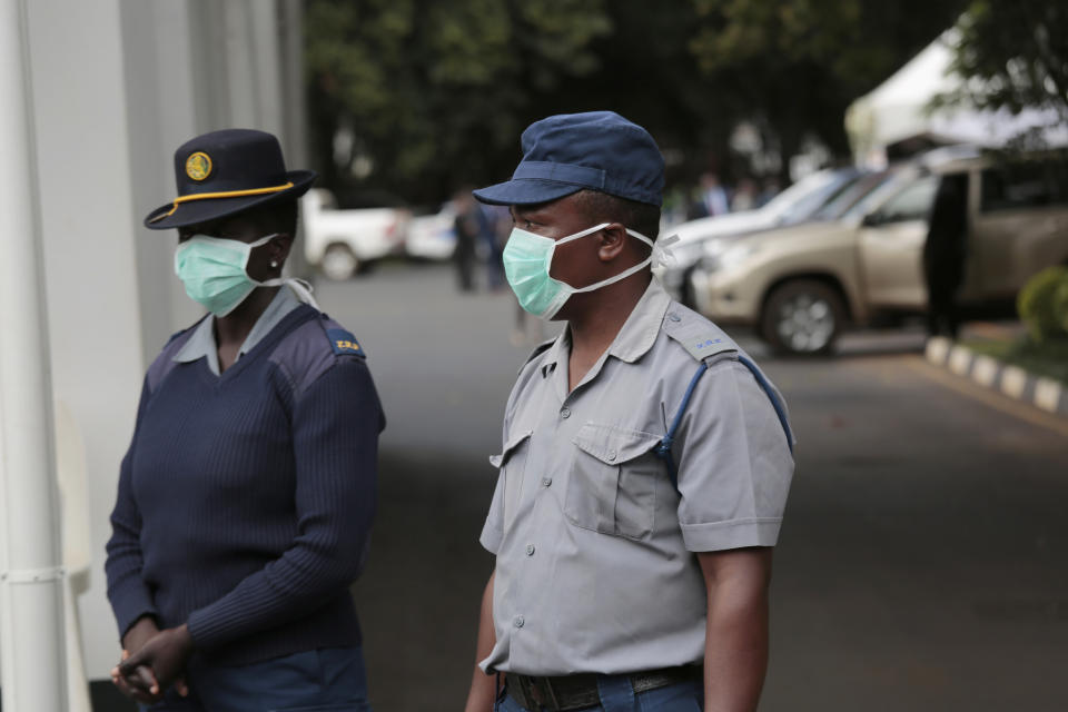 Zimbabwean police wear face masks during a coronavirus awareness campaign launch at State House in Harare, Thursday, March, 19, 2020. For most people, the new coronavirus causes only mild or moderate symptoms. For some it can cause more severe illness, especially in older adults and people with existing health problems. (AP Photo/Tsvangirayi Mukwazhi)