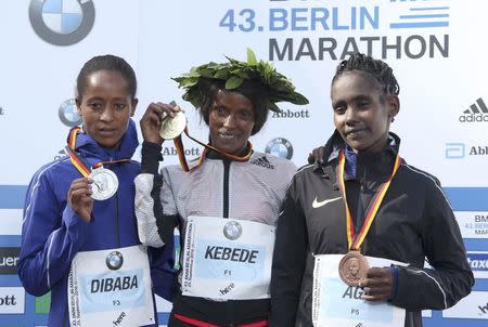 Second placed Birhane Dibaba (L to R) of Ethiopia, Aberu Kebede of Ethiopia and third-placed Ruti Aga of Ethiopia pose with their medals during the victory ceremony at the Berlin marathon in Berlin, Germany, September 25, 2016. REUTERS/Fabrizio Bensch