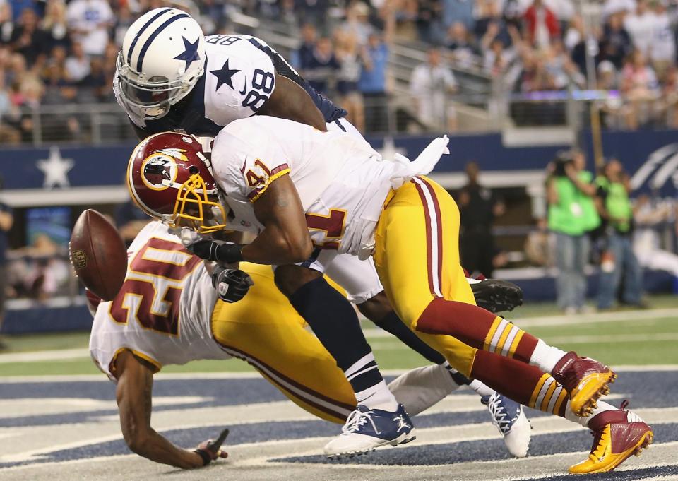 ARLINGTON, TX - NOVEMBER 22: Dez Bryant #88 of the Dallas Cowboys drops a pass in the endzone against Cedric Griffin #20 and Madieu Williams #41 of the Washington Redskins during a Thanksgiving Day game at Cowboys Stadium on November 22, 2012 in Arlington, Texas. (Photo by Ronald Martinez/Getty Images)