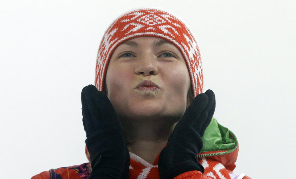 Godl medalist Belarus' Darya Domracheva throws a kiss during the flower ceremony for the women's biathlon 10k pursuit, at the 2014 Winter Olympics, Tuesday, Feb. 11, 2014, in Krasnaya Polyana, Russia. (AP Photo/Kirsty Wigglesworth)