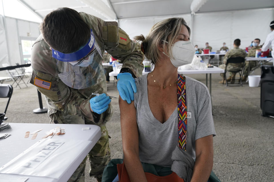 FILE - In this March 9, 2021, file photo, Liana Fonseca looks away as she receives the Pfizer COVID-19 vaccine in Miami. Despite the clamor to speed up the U.S. vaccination drive against COVID-19, the first three months of the rollout suggest faster is not necessarily better. (AP Photo/Marta Lavandier, File)