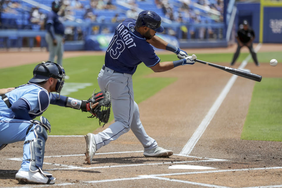 Tampa Bay Rays' Manuel Margot (13) hits an RBI-single to score Randy Arozarena in front of Toronto Blue Jays catcher Danny Jansen, left, during the first inning of a baseball game Sunday, May 23, 2021, in Dunedin, Fla. (AP Photo/Mike Carlson)