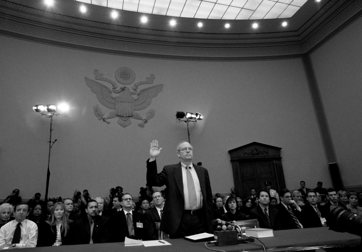 Special Prosecutor Kenneth Starr raises his hand to take the oath, with a large audience behind him.