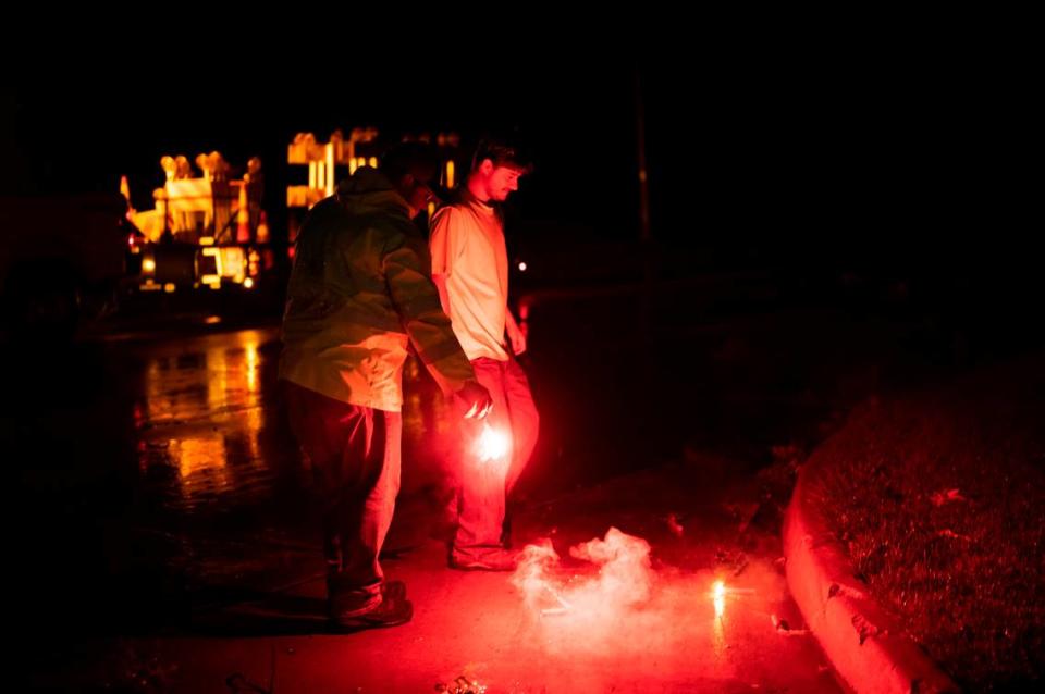 Workers put out flares on 95th Street in Leawood, KS early in the morning on June 8, 2022, after a suspected tornado struck.