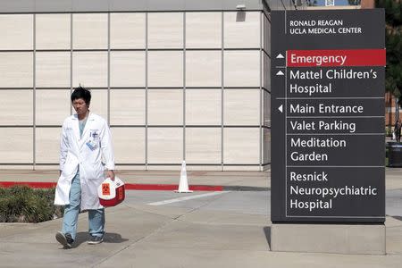 A research assistant walks past the entrance to the Ronald Reagan UCLA Medical Center in Los Angeles, California February 19, 2015. REUTERS/Jonathan Alcorn