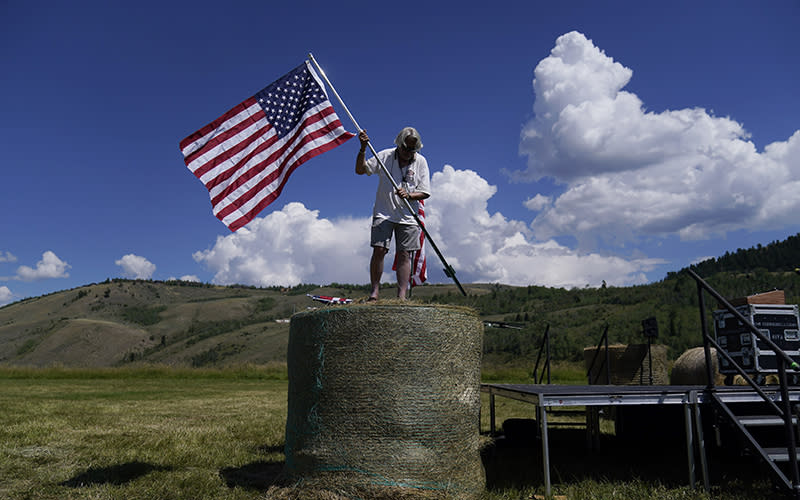 A campaign worker places an American flag on top of a hay bale