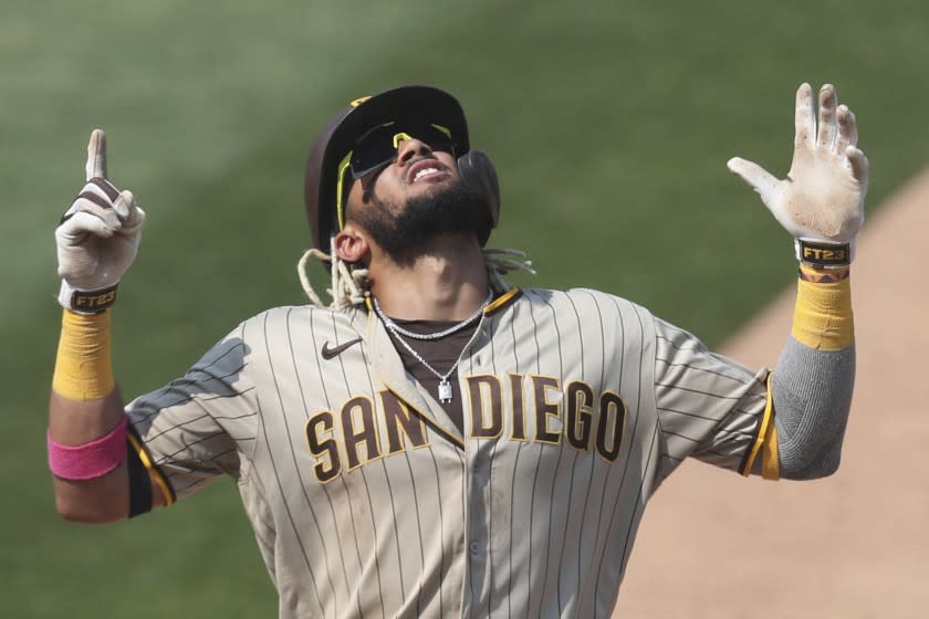 FILE - San Diego Padres' Fernando Tatis Jr. celebrates after hitting a solo home run against the Oakland Athletics during the seventh inning of a baseball game in Oakland, Calif., in this Sunday, Sept. 6, 2020, file photo. The 22-year-old star shortstop signed a $340 million, 14-year deal with the San Diego Padres, the third-highest deal in the sport's history. But the son of the only major leaguer to hit two grand slams in one inning will be giving up a percentage of his fortune to Big League Advance, a company founded in 2016 by former minor league pitcher Michael Schwimer to invest in prospects seeking an appreciation. (AP Photo/Jed Jacobsohn, File)