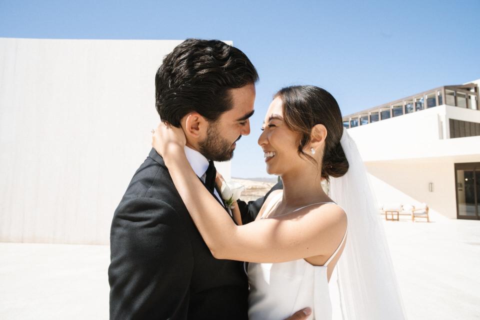 A bride and groom embrace and look into each other's eyes.