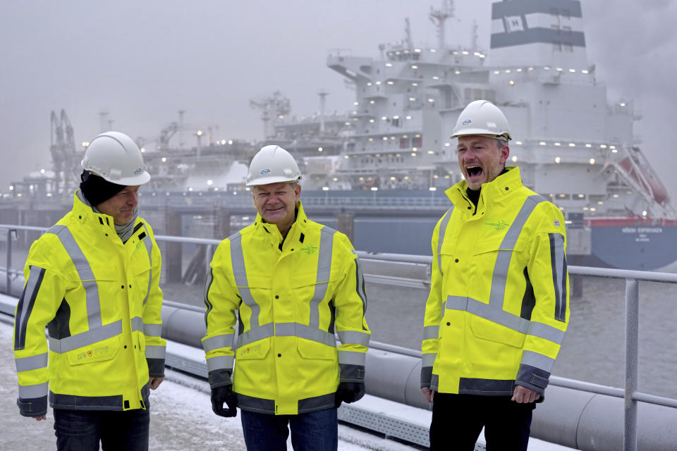 From left, German Economy and Climate Minister Robert Habeck, German Chancellor Olaf Scholz and German Finance Minister Christian Lindner, laugh as they pose in front of the 'Hoegh Esperanza' Floating Storage and Regasification Unit (FSRU) during the opening of the LNG (Liquefied Natural Gas) terminal in Wilhelmshaven, Germany, Saturday, Dec. 17, 2022. (AP Photo/Michael Sohn, pool)