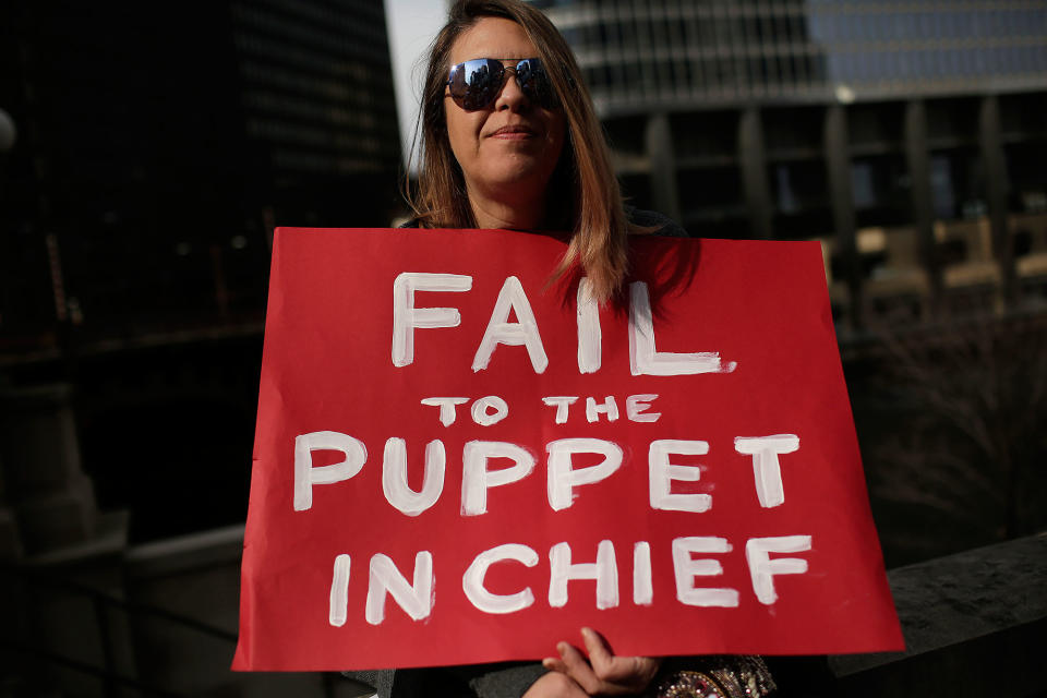 <p>A demonstrator protesting President Trump holds a sign outside Trump International Hotel & Tower during the Presidents’ Day holiday, Feb. 20, 2017, in Chicago. (Joshua Lott/AFP/Getty Images) </p>