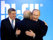 Russian President Vladimir Putin (R) embraces Federal International Football Association President Sepp Blatter as International Olympic Committee (IOC) President Thomas Bach (L) looks on at an event welcoming IOC members ahead of the upcoming 2014 Winter Olympics at the Rus Hotel on February 4, 2014, in Sochi, Russia. AFP PHOTO/POOL/DAVID GOLDMAN (Photo credit should read DAVID GOLDMAN/AFP via Getty Images)