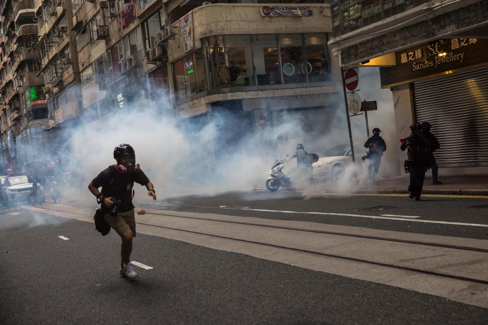 Riot police deploy flash bangs as they clear protesters from a road during a rally against a new national security law in Hong Kong on July 1, 2020, on the 23rd anniversary of the city's handover from Britain to China. - Hong Kong police made the first arrests under Beijing's new national security law on July 1 as the city greeted the anniversary of its handover to China with protesters fleeing water cannon. (Photo by DALE DE LA REY / AFP) (Photo by DALE DE LA REY/AFP via Getty Images)