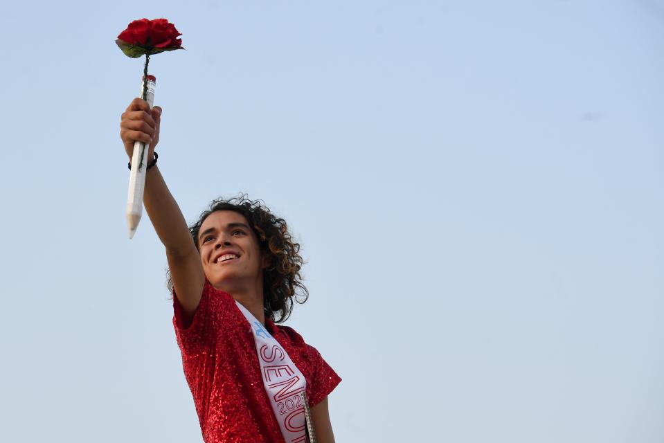 A Lincoln senior holds a flower up during the halftime performance on Friday, Sept. 15, 2023 at Howard Wood Field in Sioux Falls, South Dakota.