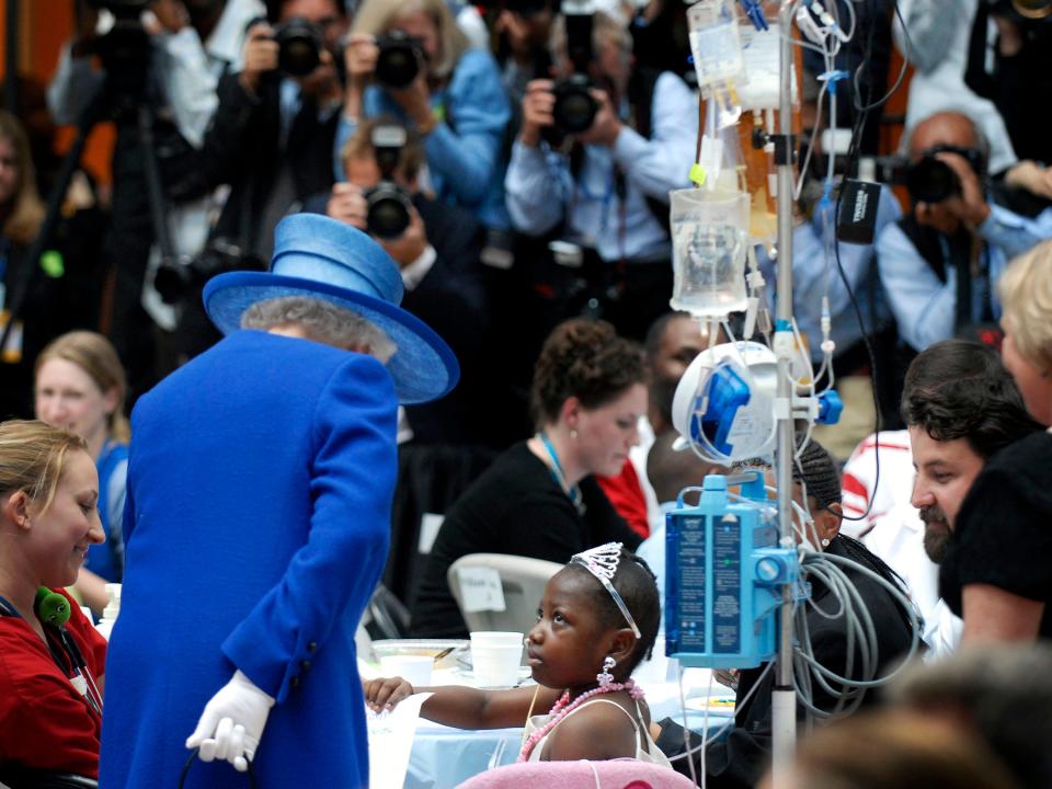 Queen Elizabeth meets a young girl wearing a tiara