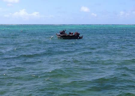 A home-made aluminium boat carrying 16 Cuban migrants floats anchored while seeking what they said was refuge from rough seas, in Grand Cayman island August 28, 2014. REUTERS/Peter Polack