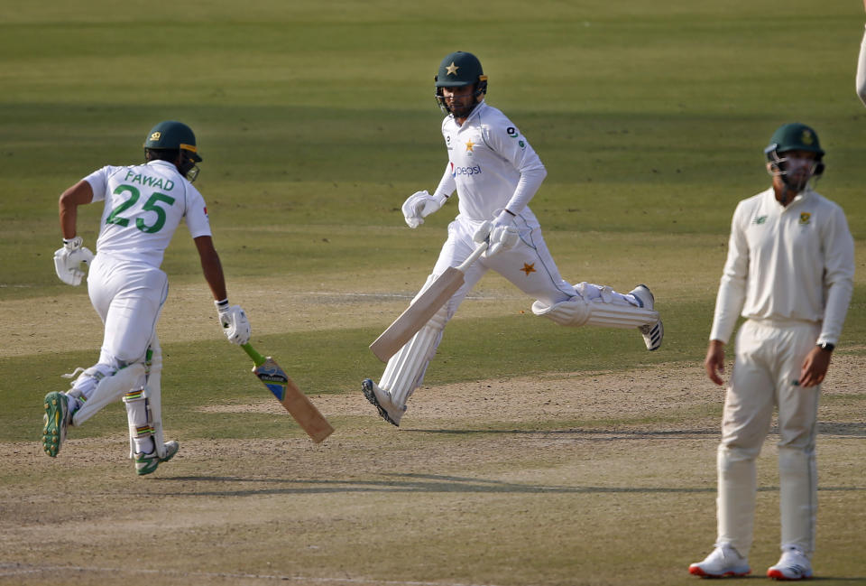 Pakistan's Faheem Ashraf, center, and Fawad Alam, left, run between the wicket while South Africa's Aiden Markram watches during the second day of the first cricket test match between Pakistan and South Africa at the National Stadium, in Karachi, Pakistan, Wednesday, Jan. 27, 2021. (AP Photo/Anjum Naveed)