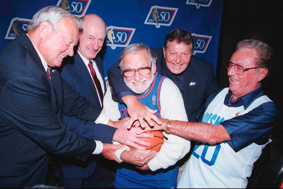 In this Oct. 31, 1996, file photo, former Toronto Huskies players, from left, Dick Schulz, Gino Sovran, Harry Miller and Ray Wertis try to steal the ball from former New York Knicks' Ossie Schectman, the first person to ever score a basket in the NBA, during an event in Toronto to commemorate the original 1946 game teams.