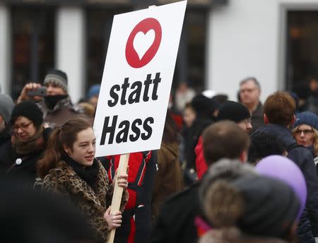 A woman holds placard during the demonstration against discrimination of migrants in Cottbus, Germany February 3, 2018. Sign reads "Instead of hate". REUTERS/Hannibal Hanschke