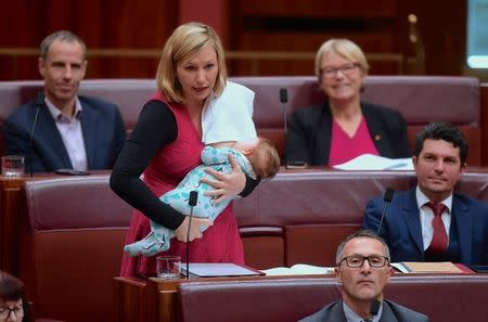 FILE PHOTO: Australian Senator Larissa Waters of the Greens Party breastfeeds her daughter Alia Joy as she speaks in the Australian Senate on school funding at Parliament House in Canberra, Australia, June 22, 2017. AAP/Lukas Coch/via REUTERS/File Photo