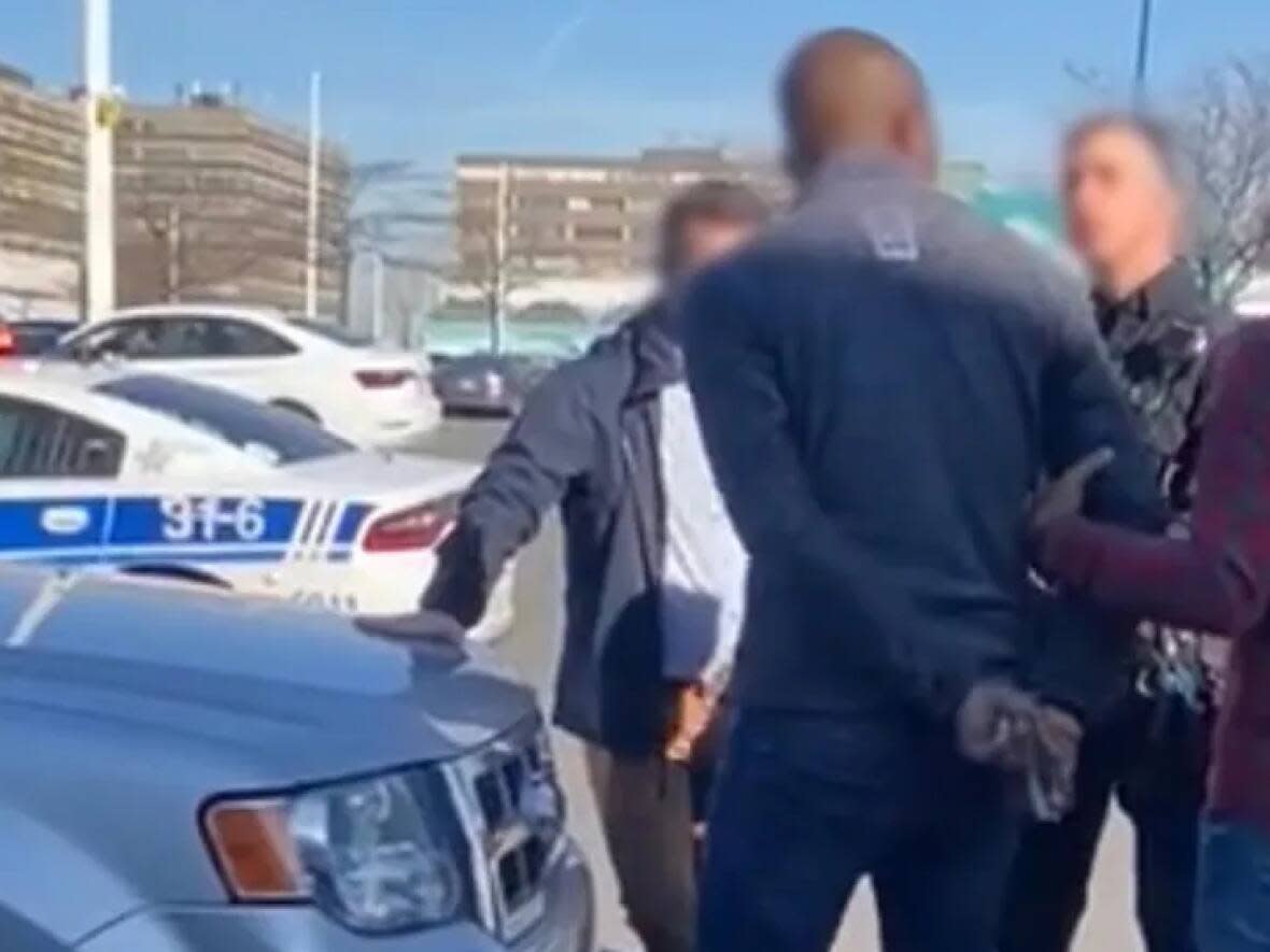 The video circulating online shows the handcuffed man insisting he is innocent and the rightful owner of the car. He asks police if a white man would be treated this way. (Screengrab of Twitter video - image credit)