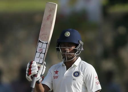 India's Wriddhiman Saha raises the bat to celebrate his half century during the second day of their first test cricket match against Sri Lanka in Galle, August 13, 2015. REUTERS/Dinuka Liyanawatte