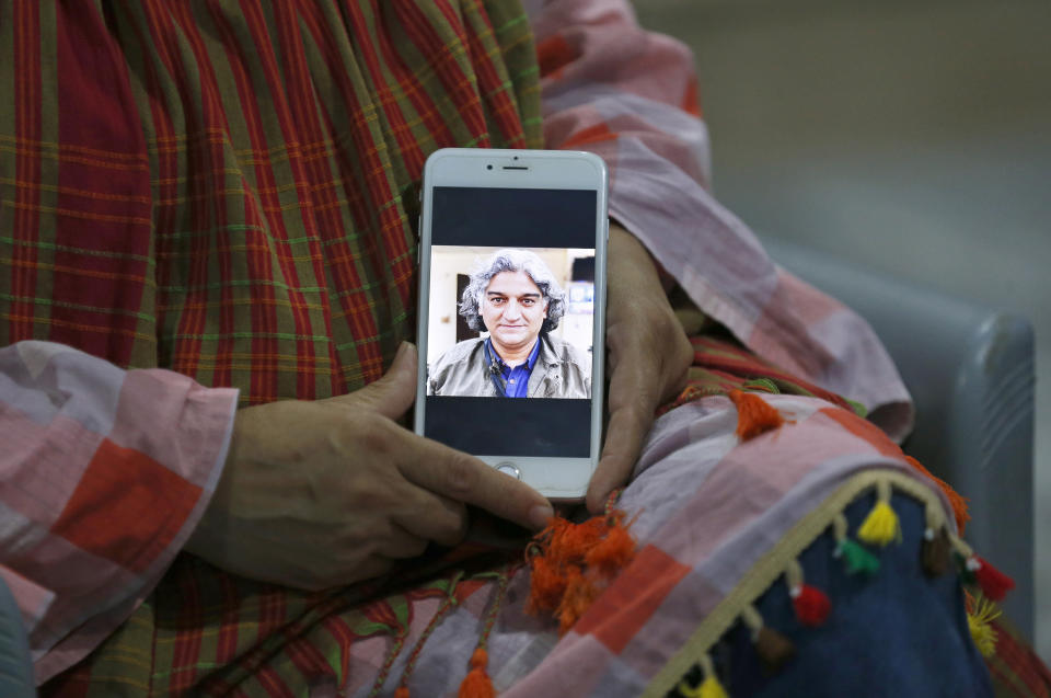 Kaneez Sughra, wife of kidnaped prominent Pakistani journalist Matiullah Jan, shows a picture her husband to journalists at a relative's home, in Islamabad, Pakistan, Tuesday, July 21, 2020. Jan, known for his hard hitting criticism of the country's powerful institutions, including its military, is missing, human rights groups and a family member said Tuesday. (AP Photo/Anjum Naveed)