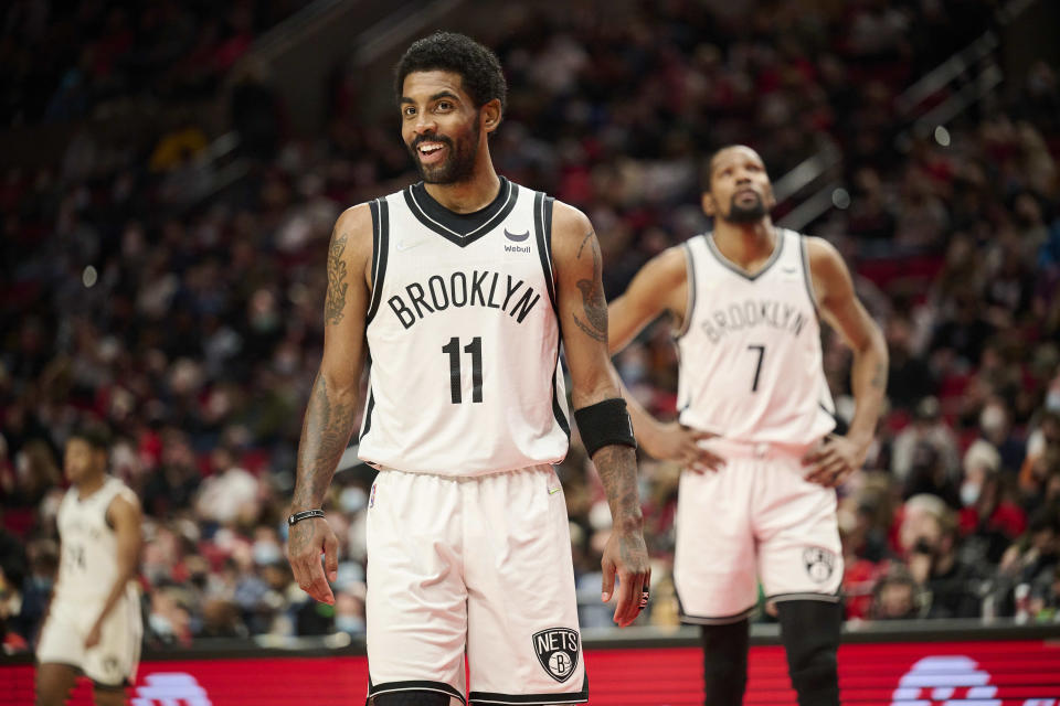 Brooklyn Nets guard Kyrie Irving and forward Kevin Durant make their way on the court after a timeout.