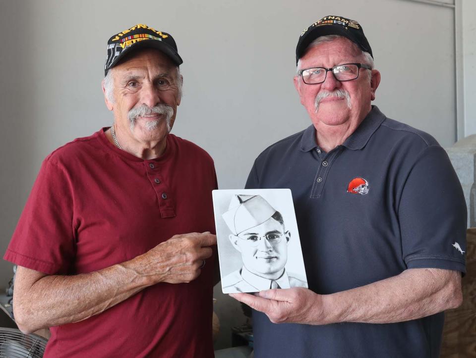 Barberton VFW Vice President Dennis Antal, left, and President Ernie Penko hold an image of Howard Woodford, a World War II hero from Barberton.