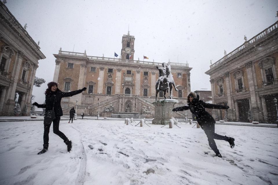 ROM03. ROMA (ITALIA), 26/02/2018.- Dos chicas se lanzan bolas de nieve frente al Campidoglio durante una intensa nevada en Roma, Italia, hoy, 26 de febrero de 2018. La ola de frío siberiano, que han llamado Burian, llegó ayer a Italia provocando copiosas nevadas en el norte y un frío intenso que ha llegado hasta los 20 grados bajo cero en algunas localidades y hoy alcanzó el centro del país y Roma, donde los colegios permanecen cerrados. EFE/ Angelo Carconi