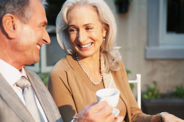 B8HX82 Couple outdoors with cup of coffee