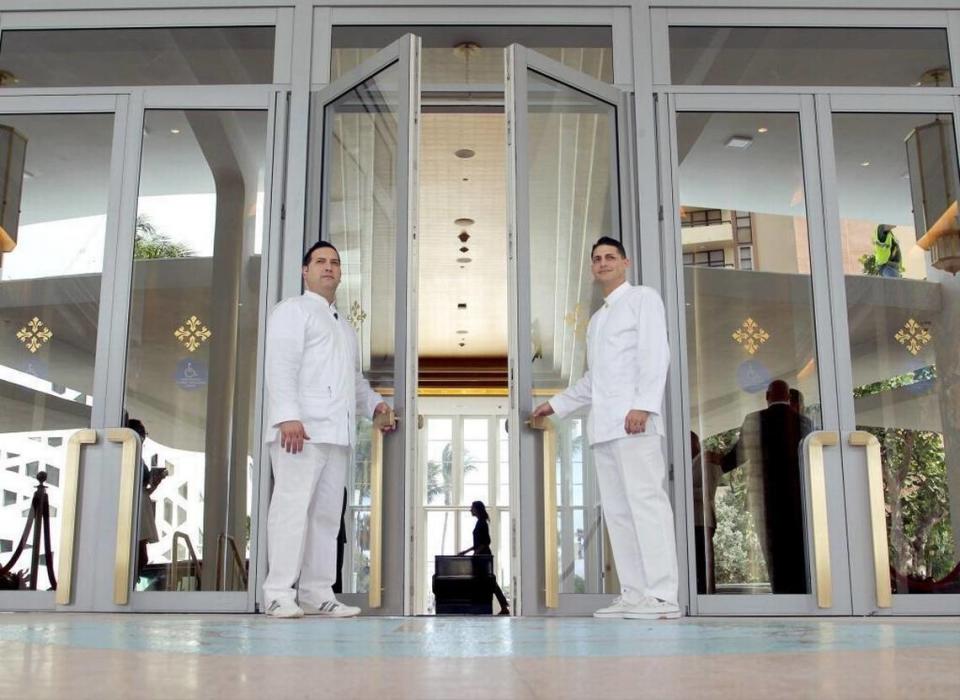Los porteros Yandy López, a la izquierda, de 41 años, y Félix Alpizar, de 38, sujetan la puerta para los huéspedes cuando entran en el característico vestíbulo del Faena Hotel, inaugurado en 2015.