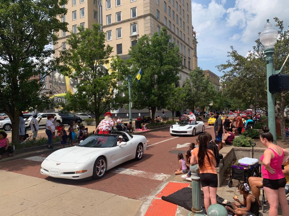 Onlookers watch and cheer as Santa Claus rides at the front of a line of sports cars Sunday during the annual Community Parade in downtown Canton. The event kicks off the Pro Football Hall of Fame Festival.