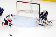 Florida Panthers' Colton Sceviour, left, watches a puck slide past St. Louis Blues goaltender Jordan Binnington during the second period of an NHL hockey game Monday, March 9, 2020, in St. Louis. (AP Photo/Jeff Roberson)