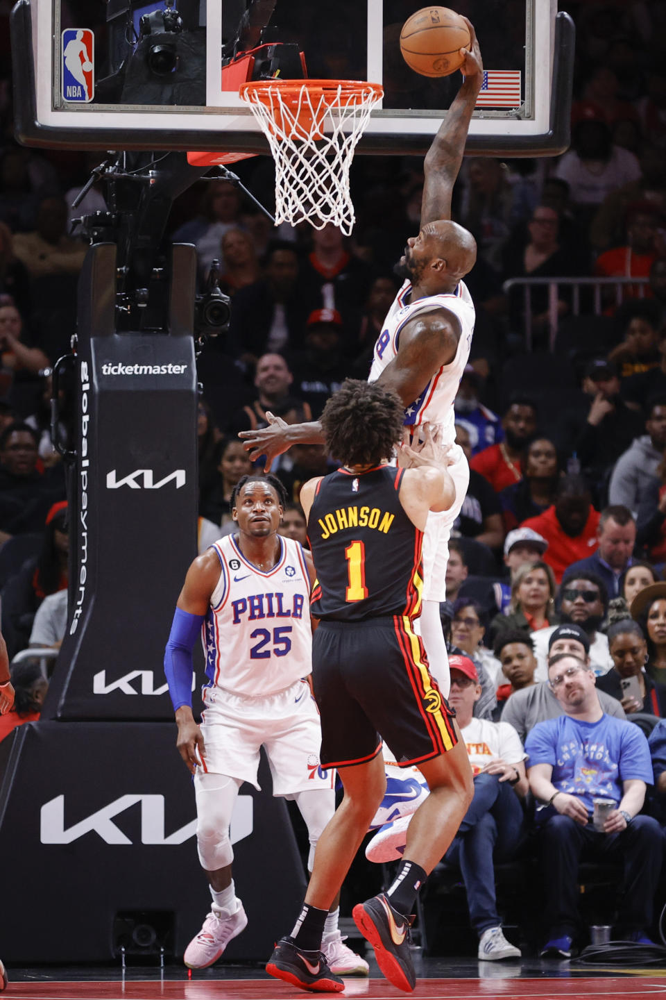 Philadelphia 76ers center Dewayne Dedmon, top, dunks over Atlanta Hawks forward Jalen Johnson (1) during the first half of an NBA basketball game Friday, April 7, 2023, in Atlanta. (AP Photo/Alex Slitz)