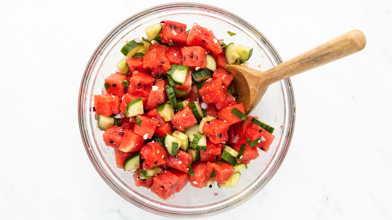 mixing watermelon salad in bowl