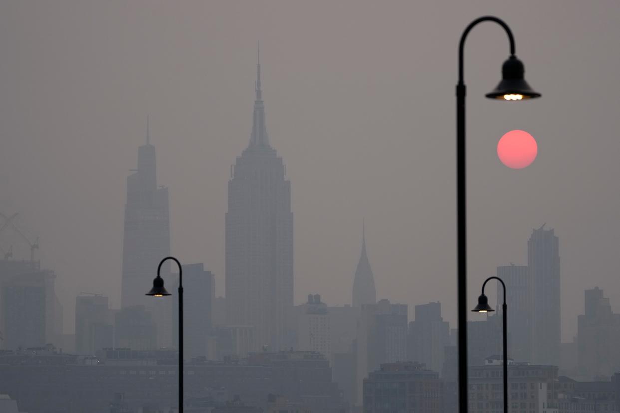 The sun rises over a hazy New York City skyline as seen from Jersey City, N.J., Wednesday, June 7, 2023. Intense Canadian wildfires are blanketing the northeastern U.S. in a dystopian haze, turning the air acrid, the sky yellowish gray and prompting warnings for vulnerable populations to stay inside. (AP Photo/Seth Wenig)