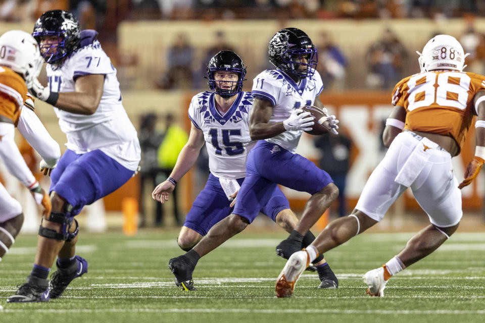 TCU quarterback Max Duggan (15) hands off to TCU wide receiver Derius Davis (11) during the first half of the team's NCAA college football game against Texas on Saturday, Nov. 12, 2022, in Austin, Texas. (AP Photo/Stephen Spillman)