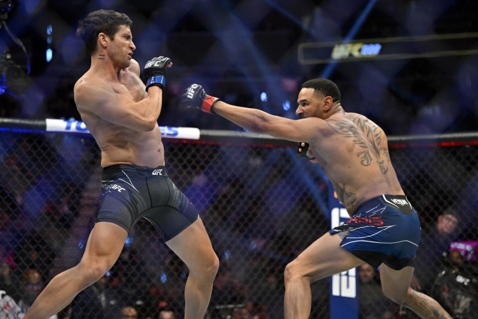 Two men swinging at each other in a fighting ring