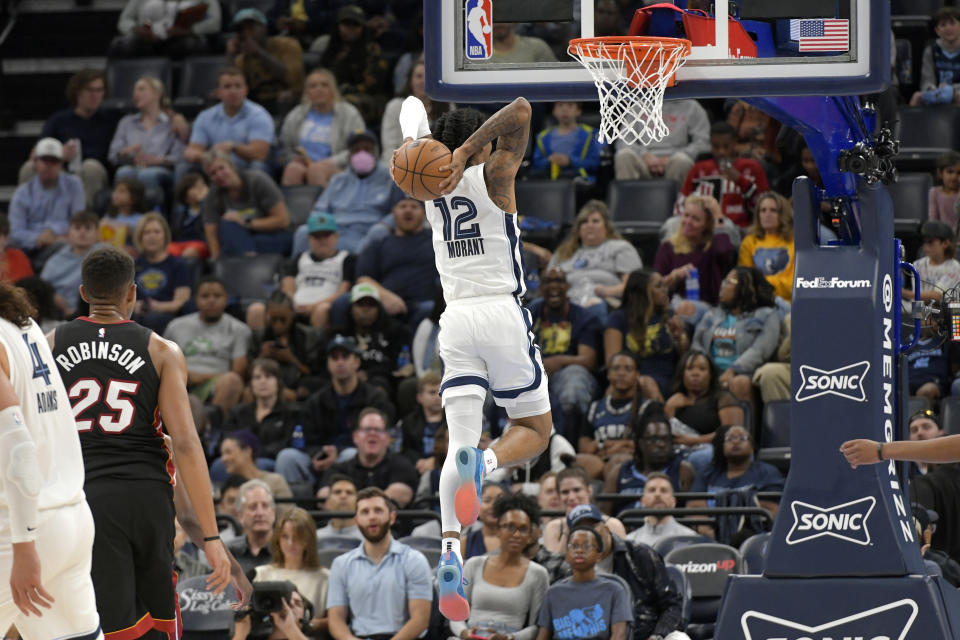 Memphis Grizzlies guard Ja Morant (12) goes up for a dunk against the Miami Heat in the first half of a preseason NBA basketball game Friday, Oct. 7, 2022, in Memphis, Tenn. (AP Photo/Brandon Dill)