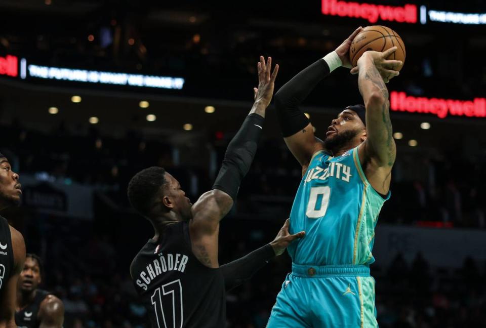 Charlotte Hornets forward Miles Bridges, right, shoots past a block by Brooklyn Nets guard Dennis Schroder at the Spectrum Center in Charlotte, N.C., on Saturday, March 9, 2024.